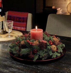 Kersttafel Arrangement. Een mooi rondom een kaars opgestoken kerst arrangement wat u zo op de dinertafel kan plaatsen. Kerstdecoratie. Skimmia, denneappels. Nootdorp. Fleurettes.